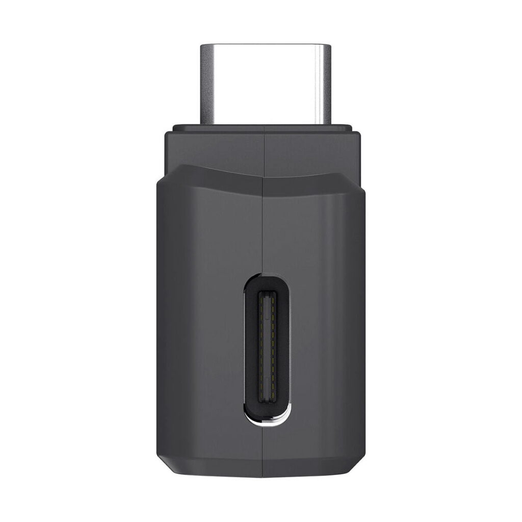 Insta360_One_X2_3_5mm_Mic_Adapter_with_Charging_Input_005 Lähikuva Insta360 One X2 3,5 mm:n mikrofonisovittimesta, jossa on USB-C-portti etupuolella ja USB-C-liitin yläpuolella, valkoista taustaa vasten.