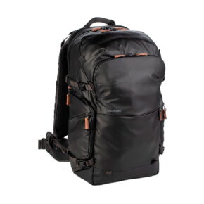 Shimoda Designs Explore v2 35 -kamerareppu mustana sisältää ruskeat vetoketjunvetimet, useita lokeroita, säädettävät hihnat ja pehmustetun lantiovyön - ihanteellinen matkoille tai ulkokäyttöön. Shimoda-logo näkyy edessä.