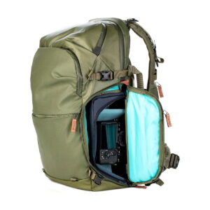 Shimoda Designs Explore v2 35 -kamerareppu, vihreä, on väriltään oliivinvihreä ja siinä on ruskeat vetoketjunvetimet, pehmustettu turkoosilla vuorattu kameralokero sekä useita taskuja ja hihnoja organisoitua kantamista varten.