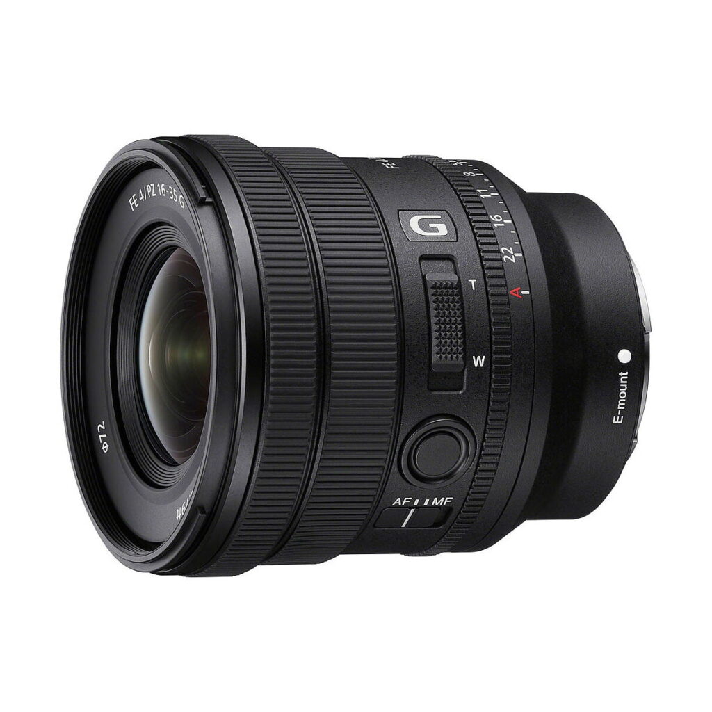 Sony_FE_PZ_16-35mm_f_4_G_003 Musta Sony FE PZ 16-35mm f/4 G -objektiivi, jossa on zoomaus- ja tarkennusrenkaat, G- ja E-mount-merkinnät, aukkorengas ja AF/MF-kytkin, näkyy valkoista taustaa vasten.