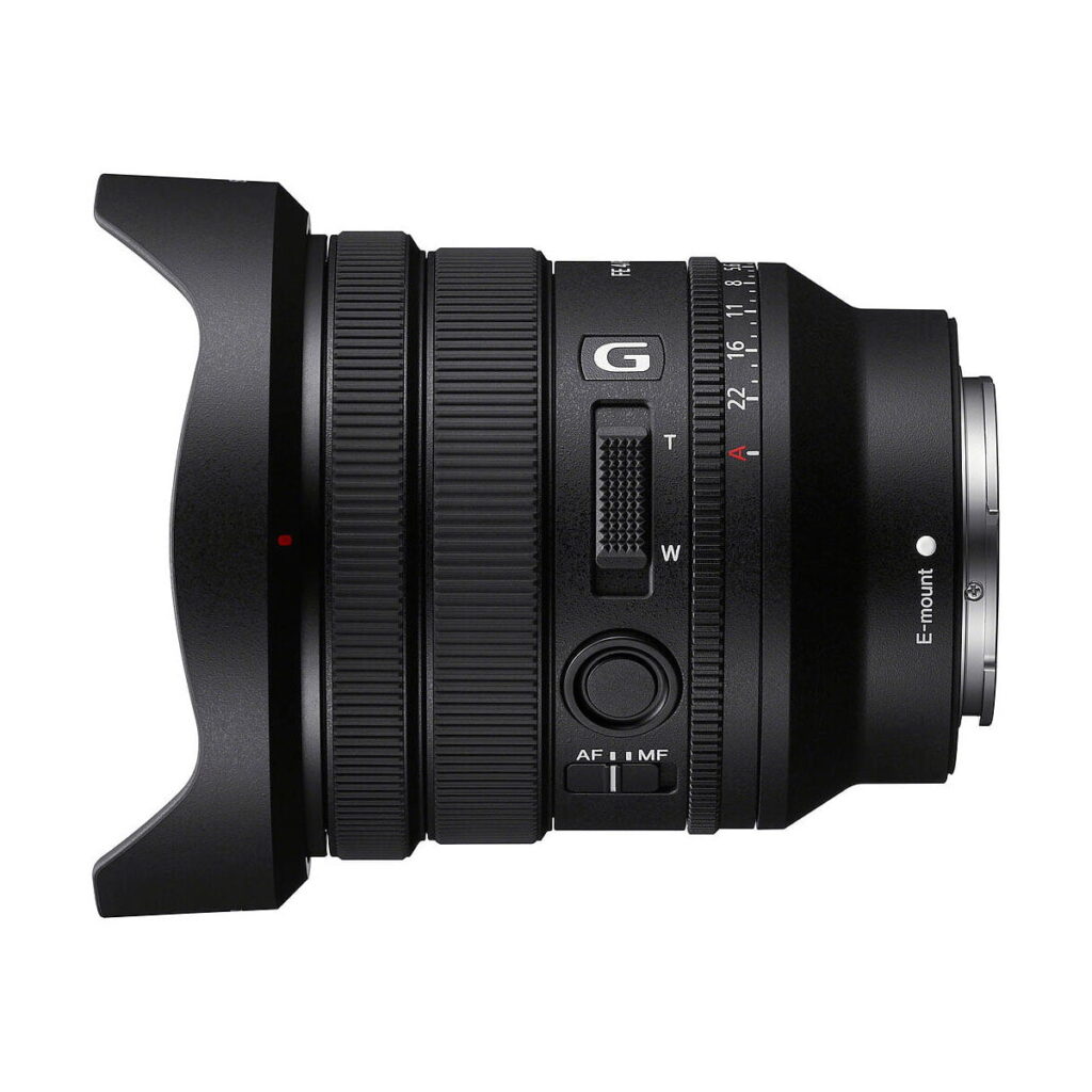 Sony_FE_PZ_16-35mm_f_4_G_004 Sivukuva mustasta Sony FE PZ 16-35mm f/4 G -objektiivista, jossa on tarkennusrengas ja zoomausrengas, useita säätökytkimiä ja terälehden muotoinen vastavalosuoja valkoisella pohjalla.