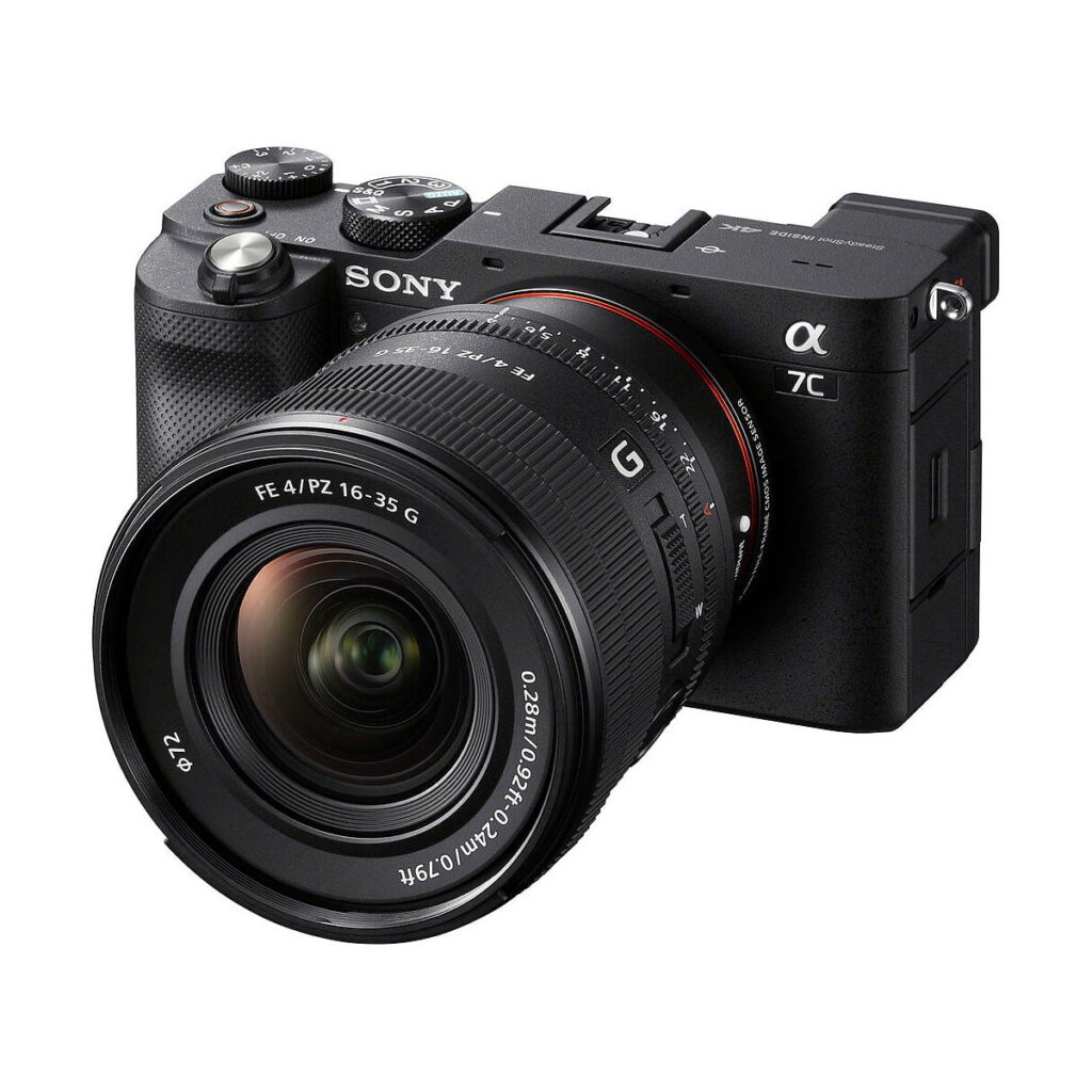 Sony_FE_PZ_16-35mm_f_4_G_007 Musta Sony Alpha 7C -peilitön kamera, johon on kiinnitetty Sony FE PZ 16-35mm f/4 G -objektiivi ja jossa on erilaisia painikkeita ja valitsimia ylä- ja sivupuolella.