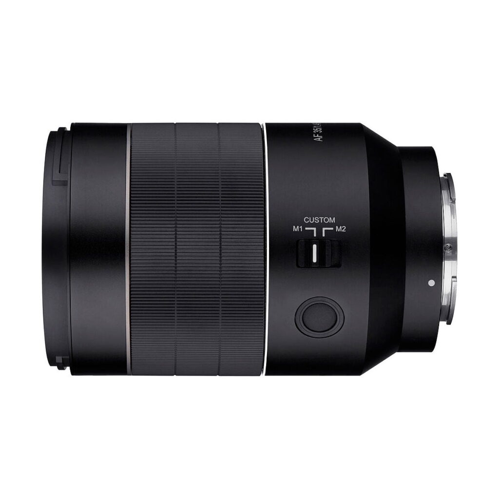 Samyang_35mm_f_1_4_AF_II_005 Mustassa Samyang AF 35mm f/1.4 II - Sony E -objektiivissa on kuvioitu zoomausrengas, mukautettu M1/M2-kytkin ja pyöreä sivupainike valkoista taustaa vasten.