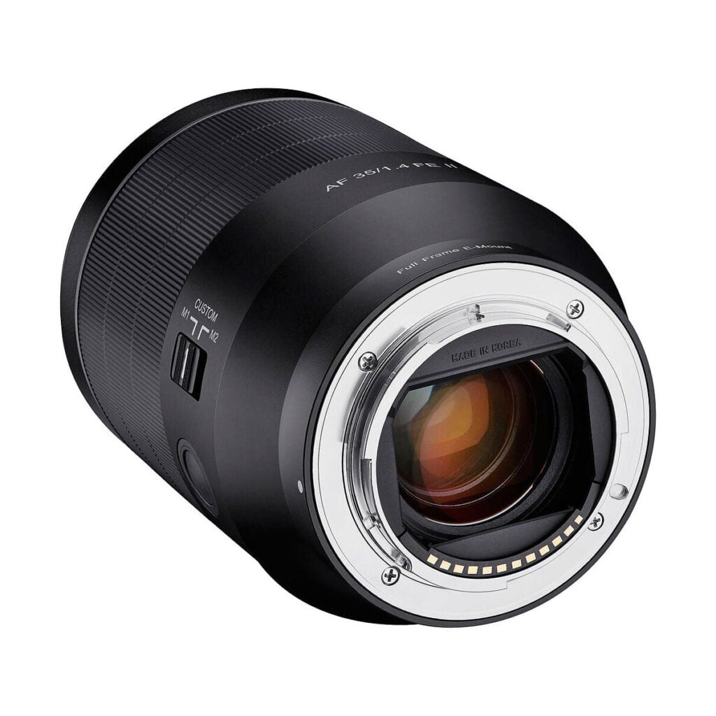 Samyang_35mm_f_1_4_AF_II_006 Lähikuvassa Samyang AF 35mm f/1.4 II for Sony E -objektiivista näkyy elektroniset koskettimet ja lasi objektiivin kiinnikkeessä sekä näkyvät kytkimet ja merkinnät tynnyrissä.