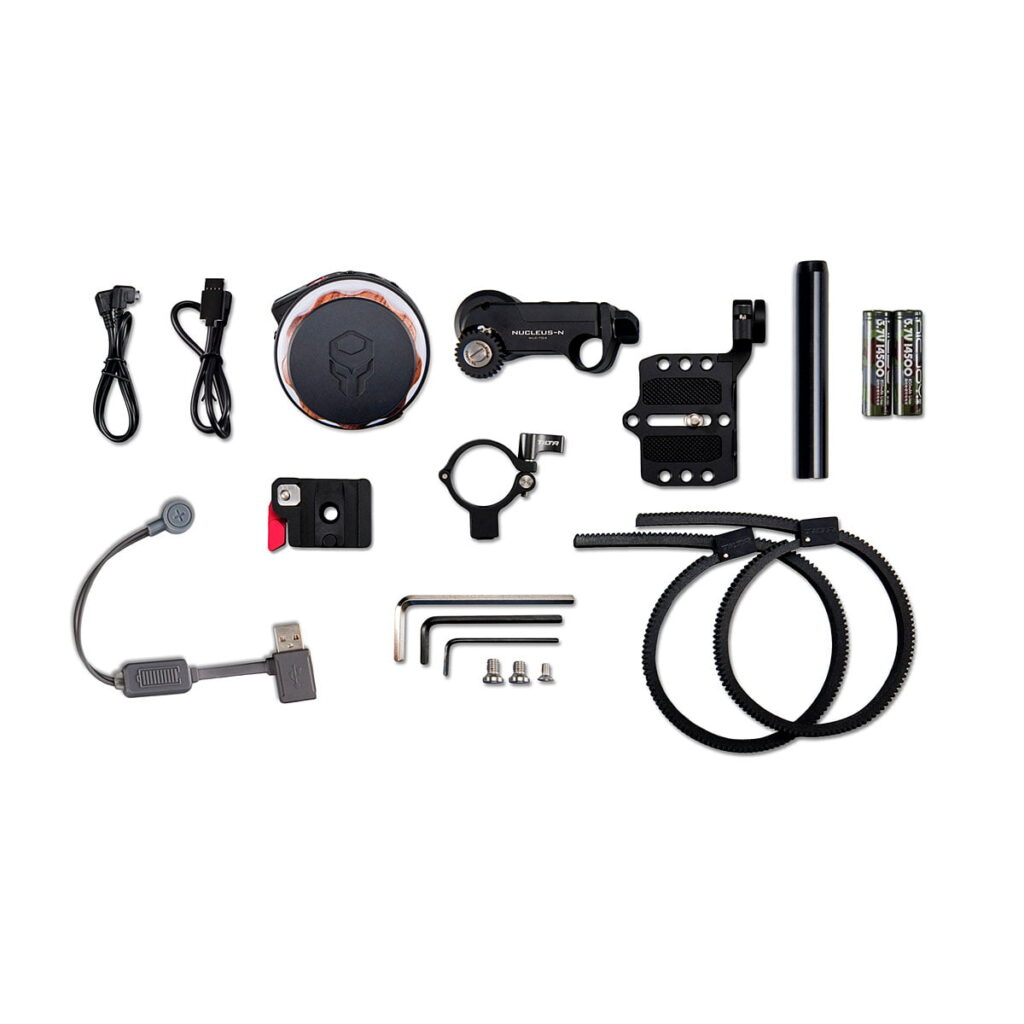 Tilta_Nucleus-Nano_Wireless_Focus_Control_System_000 Tilta Nucleus-Nano Wireless Focus Control System -järjestelmän komponentit - mukaan lukien kaapelit, pyöreä ohjain, kiinnityskannattimet, asetusruuvit, paristot, nippusiteet, kuusiokoloavaimet, ohjaustankokiinnike ja USB-sovitin - ovat siististi järjestettyinä valkoisella pohjalla.