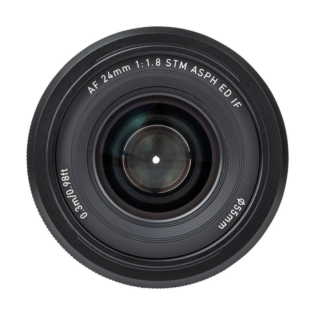 Viltrox_AF_24mm_f_1_8-Nikon_Z_004 Viltrox AF 24mm f/1.8 -objektiivi, Nikon Z -objektiivin yläkuva, jossa on merkintä "AF 24mm 1:1.8 STM ASPH ED/IF, 0.3m/0.98ft, Ø55mm"; objektiivin lasi on keskitetty ja sitä ympäröivät mustat renkaat.