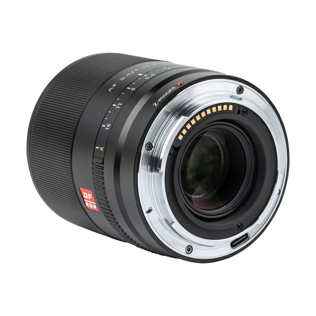 Viltrox_AF_24mm_f_1_8-Nikon_Z_007 Nikon Z:lle tarkoitetun Viltrox AF 24mm f/1.8 -objektiivin lähikuvassa näkyy metallinen objektiivin kiinnitys, elektroniset koskettimet ja tarkennus-/aukkomerkinnät mustassa tynnyrissä, jossa on punainen DF- ja RF-merkintä.