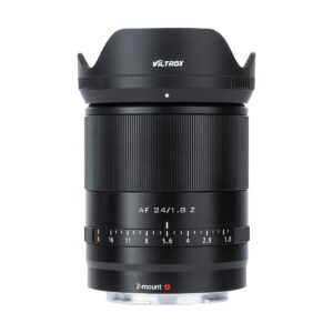 Viltrox_AF_24mm_f_1_8-Nikon_Z_009 Viltrox AF 24mm f/1.8 -objektiivi, Nikon Z, jossa on musta runko, uurrettu tarkennusrengas, aukkomerkinnät ja terälehden muotoinen vastavalosuoja, näkyy pystyssä valkoista taustaa vasten.