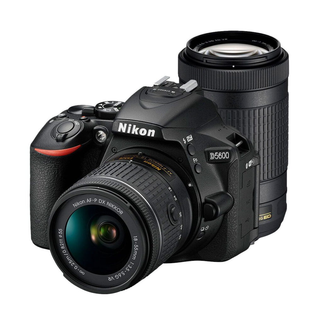 nikon-d5600-af-p-18-55-vr-af-p-70-300-vr Nikon D3500 -kamera ja siihen kiinnitetty Nikkor AF-P DX 18-55mm VR -objektiivi sekä sen takana oleva erillinen AF-P DX 70-300 VR -objektiivi näkyvät valkoisella taustalla.