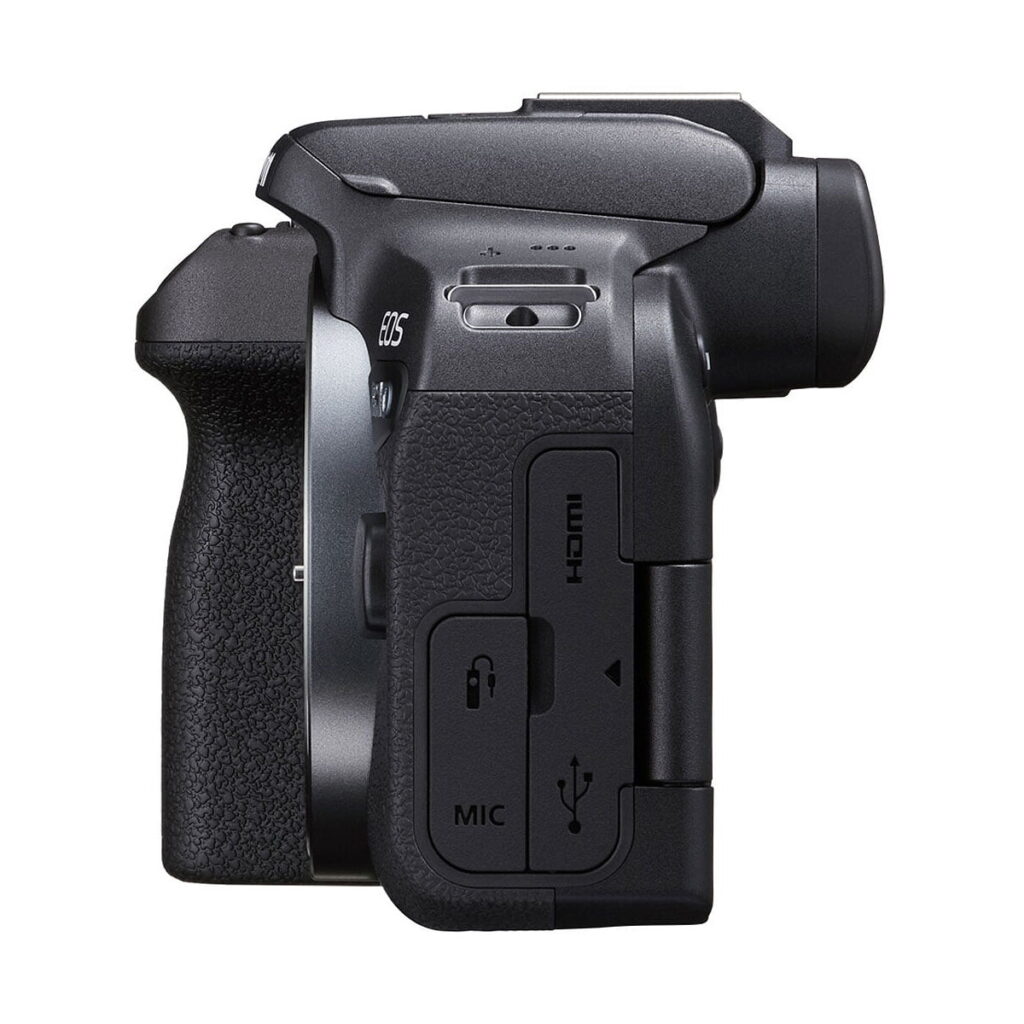 Canon_EOS_R10_005 Sivunäkymä Canon EOS R10 -järjestelmäkameran musta, osoittaa kahva rakenne ja peitetty HDMI, MIC, ja USB-portit, etsimen ja tilan valitsin osittain näkyvissä päälle.