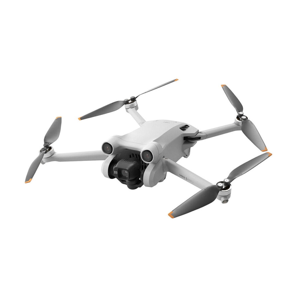 DJi_Mini_3_Pro_001 DJI Mini 3 Pro (ei RC) on valkoinen nelikopteri, jossa on neljä oransseilla kärjillä varustettua potkuria ja etukamera, joka näkyy valkoista taustaa vasten.