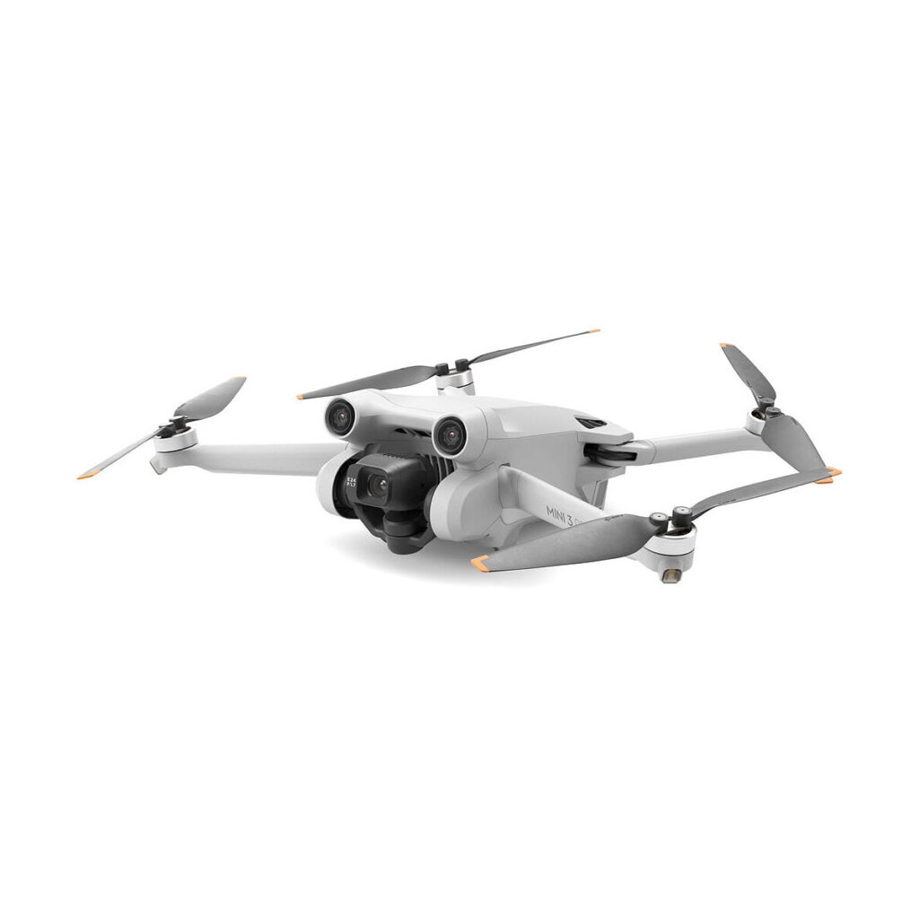 DJi_Mini_3_Pro_Smart_Controller_004 DJI Mini 3 Pro + RC-N1 Ohjain on kompakti valkoinen nelikopteri, jossa on neljä oransseilla kärjillä varustettua rekvisiittaa, etukamera, ja se on kuvattu valkoista taustaa vasten.
