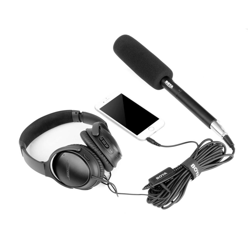 Boya-BY-BCA6-3 Mustat over-ear-kuulokkeet, älypuhelin ja Boya BY-BCA6 XLR - 3,5 mm TRRS -sovitin, jossa on pitkä musta kaapeli, on sijoitettu valkoiselle taustalle.