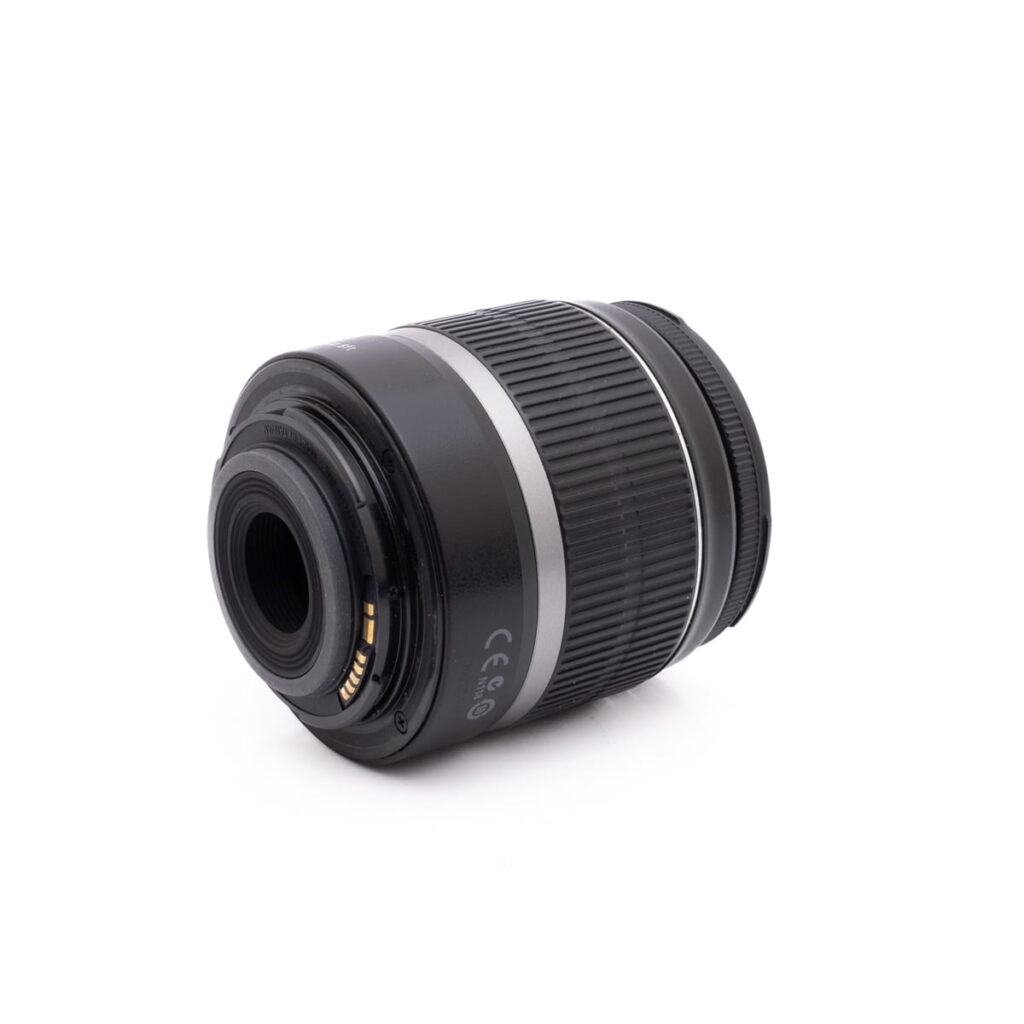 Sigma 30mm f/1.4 DC DN Sony E - Käytetty musta objektiivi, jossa on hopeinen rengas, lepää kyljellään valkoista taustaa vasten, jossa näkyy objektiivin kiinnitys ja elektroniset kontaktit.