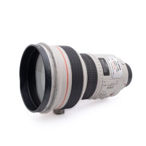 Canon 200mm f1.8L-2 Käytetty Olympus OM-D E-M1X (SC 460) -kamera on kuvassa hieman vasemmalle suunnattuna valkoista taustaa vasten.