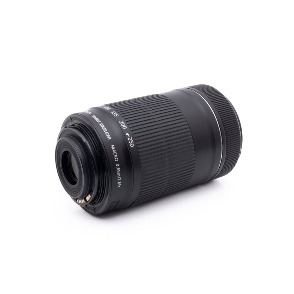 Canon 55-250mm f4-5.6-3 Sigma 30mm f/1.4 DC DN Sony E - Käytetty musta kameran zoom-objektiivi makaa kyljellään valkoista taustaa vasten, ja siinä näkyvät takakiinnitys, automaattitarkennuksen kontaktit ja polttovälin merkinnät.