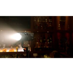 Forza-60C-7 NANLITE Forza 60C RGBLAC Led Spotlight valaisee kirkkaasti hämärästi valaistua baaria ja valaisee taustalla olevia hyllyjä, joissa on erilaisia pulloja.
