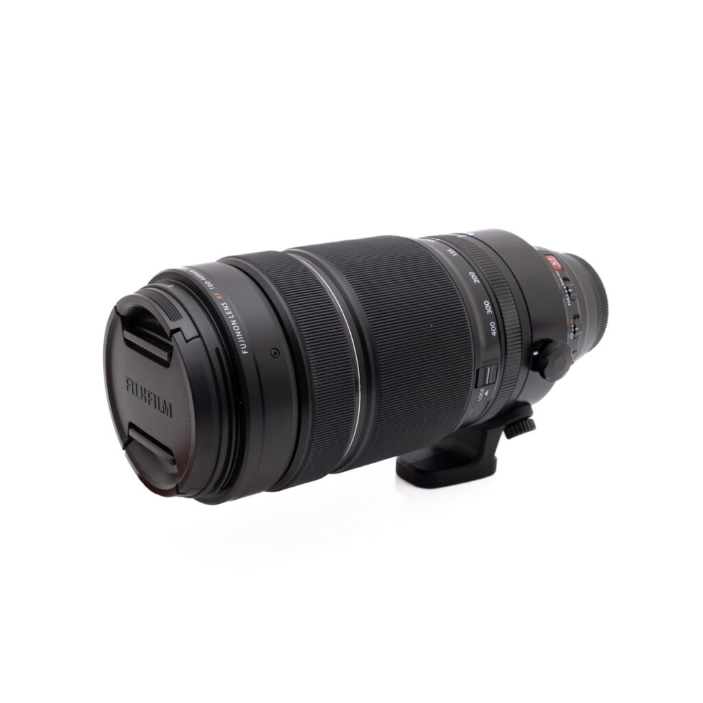 Fujinon 100-400mm-1 Musta Olympus OM-D E-M1X (SC 460) - Käytetty kamera, jossa on zoomaus- ja tarkennusrenkaat sekä jalustakiinnityskaulus, on kuvattu valkoisella taustalla.