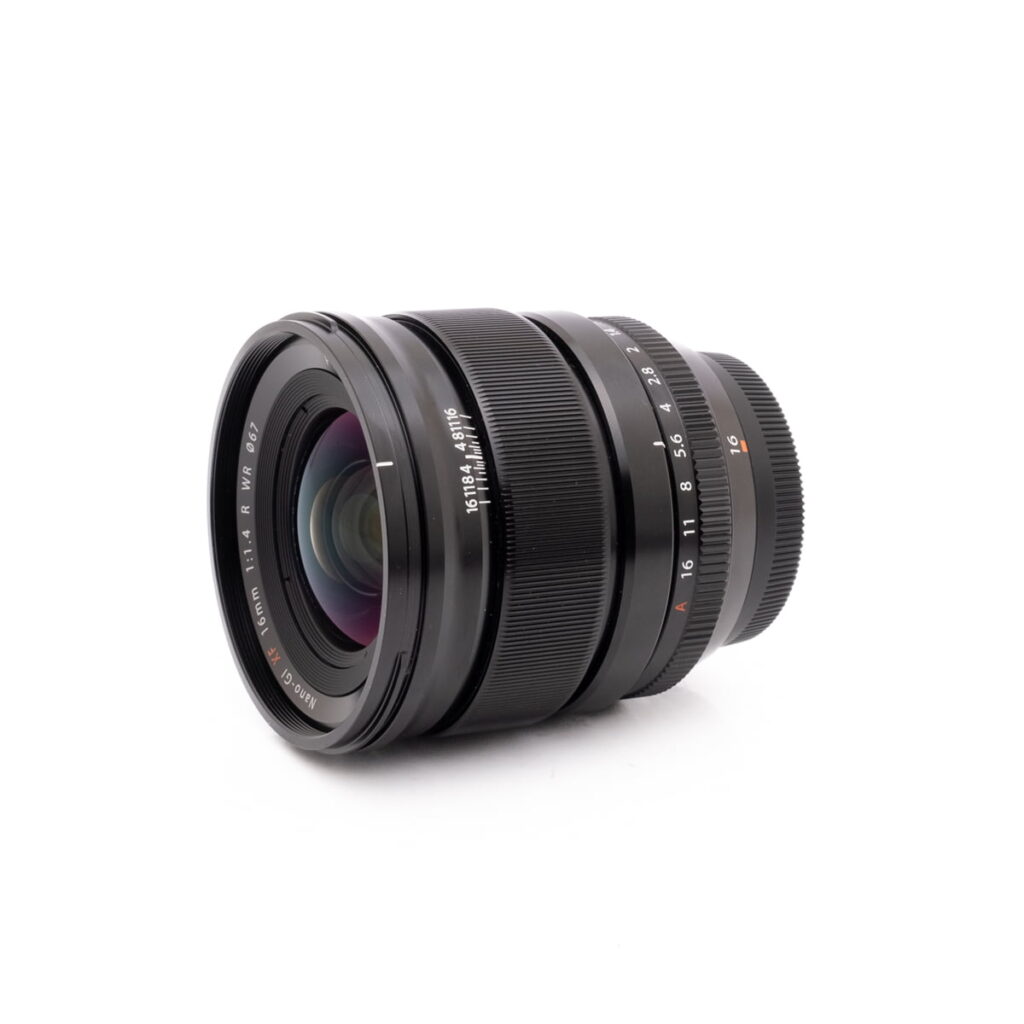 Fujinon 16mm f1.4-2 Olympus OM-D E-M1X (SC 460) - Käytetty kamerarunko näkyy valkoisella pohjalla, hieman vasemmalle suunnattuna.
