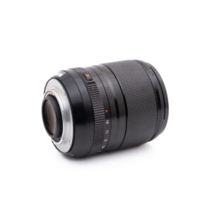 Fujinon 23mm f1.4-3 Olympus OM-D E-M1X (SC 460) - Käytetty vaihdettava kameran objektiivi, jossa on uurrettu kahva, aukkomerkinnät ja metallinen kiinnitysrengas, on kuvattu kyljellään valkoista taustaa vasten.