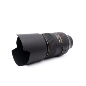 Nikon Nikkor Z DX 16-50mm f/3.5-6.3 VR - Käytetty objektiivi, musta, jossa on vastavalosuoja kiinnitettynä, kuvattuna kulmassa valkoisella taustalla, jossa on ohjauskytkimet ja kultainen erittelyteksti.