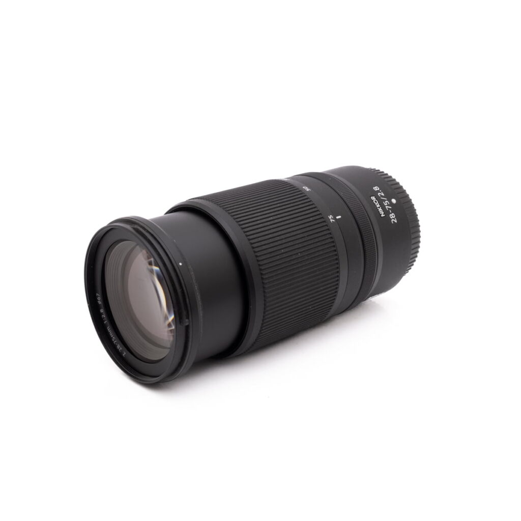 Nikkor 28-75mm f2.8-2 Sigma 30mm f/1.4 DC DN Sony E - Käytetty objektiivi, jossa on kuvioidut pitorenkaat, näkyy valkoisella pohjalla, ja se on kuvakulmattu korostamaan lasin ja piipun yksityiskohtia.