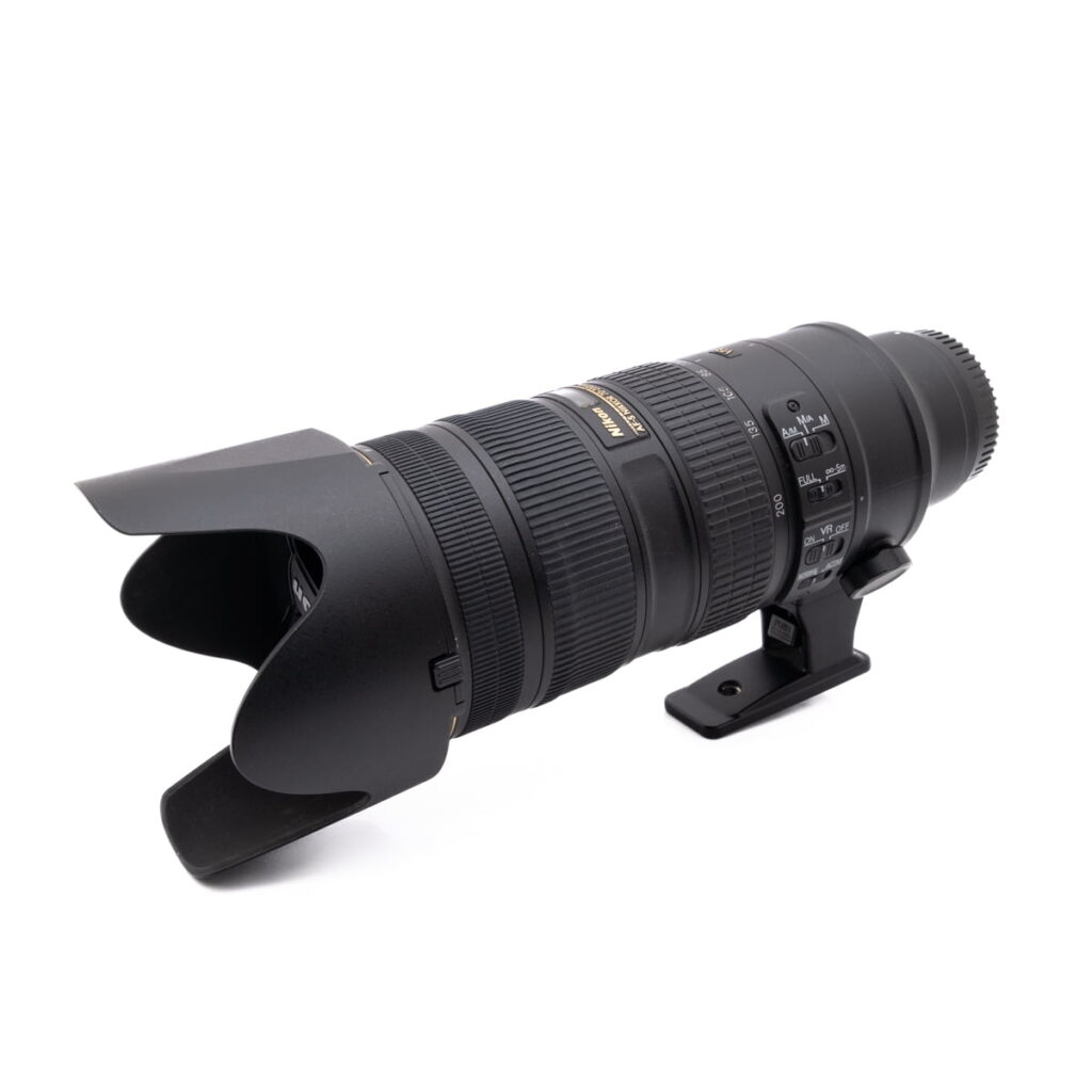 Nikkor 70-200mm f-2.8 5340-1 Käytetty Nikon AF-S Nikkor 50mm f/1.8 G (Kunto K4.5) -kameran objektiivi näkyy valkoisella pohjalla, ja siinä on näkyvissä ohjauskytkimet ja piipun merkinnät.