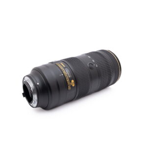 Nikkor 70-200mm f2.8-3 Käytetty Canon Speedlite 430EX, jossa on musta runko ja valkoiset merkinnät, lepää kyljellään valkoista taustaa vasten, ja sen kiinnitys ja ohjauspaneeli näkyvät.