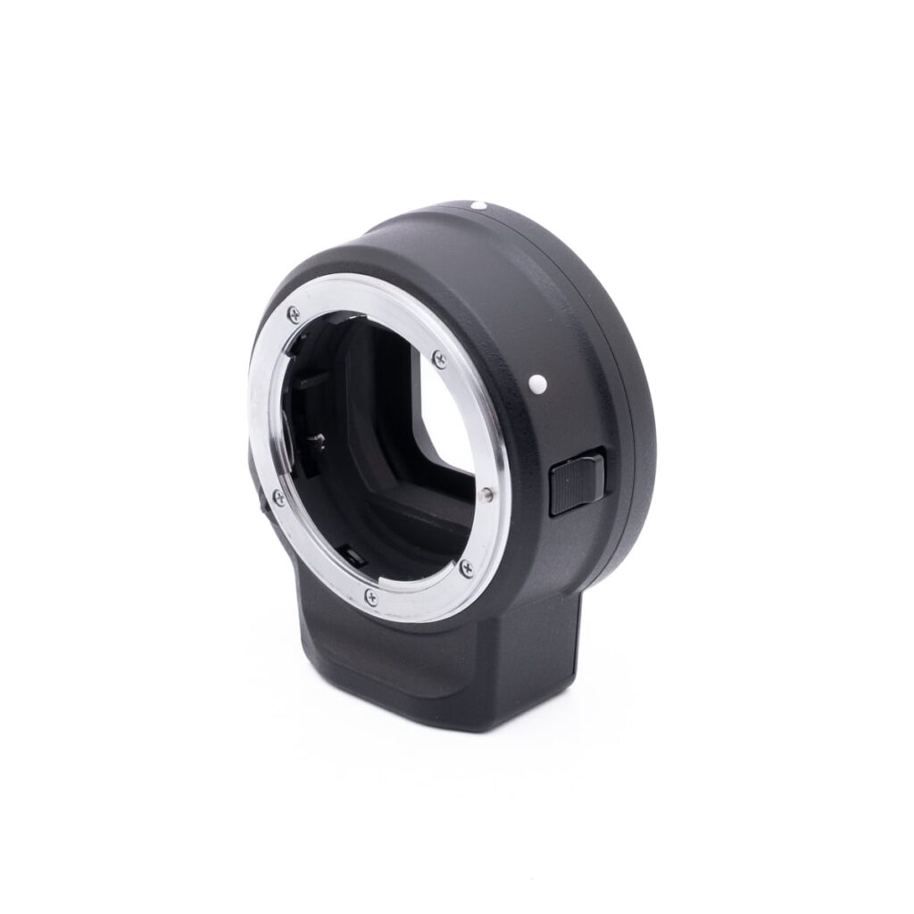 Lähikuva Canon Speedlite 430EX - Käytetty -valaisimesta, jossa on musta ja hopeinen viimeistely, kuvattuna valkoista taustaa vasten.