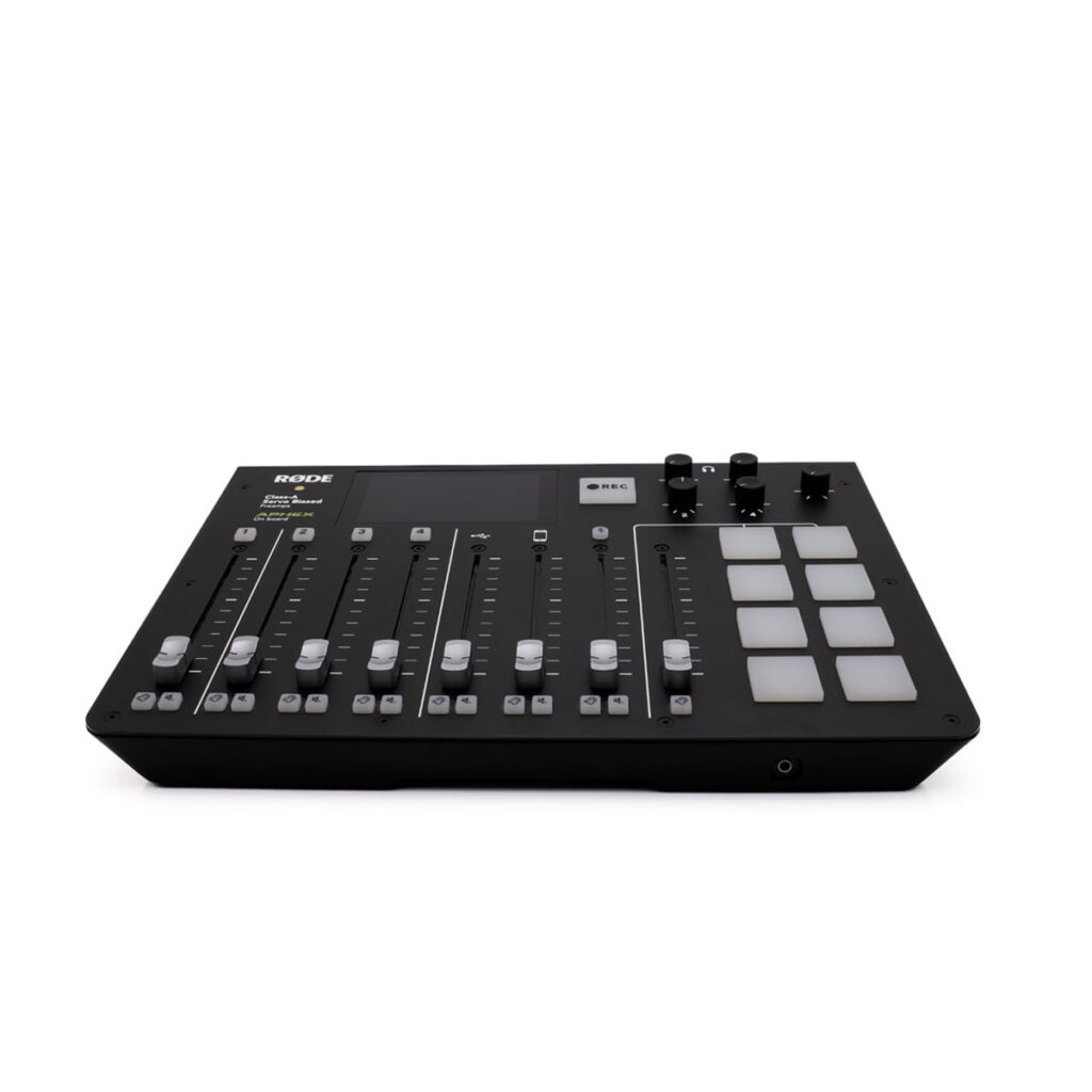 RodeCaster pro RodeCaster Pro (Kunto K5, Takuu 6kk) - Käytetty on musta äänimikseri, jonka yläpinnalla on useita liukusäätimiä, painikkeita, nuppineuvoja ja neliönmuotoisia padeja valkoisella pohjalla.