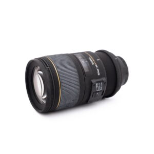 Sigma 150mm f-2.8 macro NikonF-2 Nikon AF-S Nikkor 50mm f/1.8 G (Kunto K4.5) - Käytetty musta objektiivi, jossa on kultaisia aksentteja, makaa kyljellään valkoista taustaa vasten, ja siinä näkyvät tarkennusrengas ja zoomausrengas sekä sivussa olevat merkityt kytkimet.