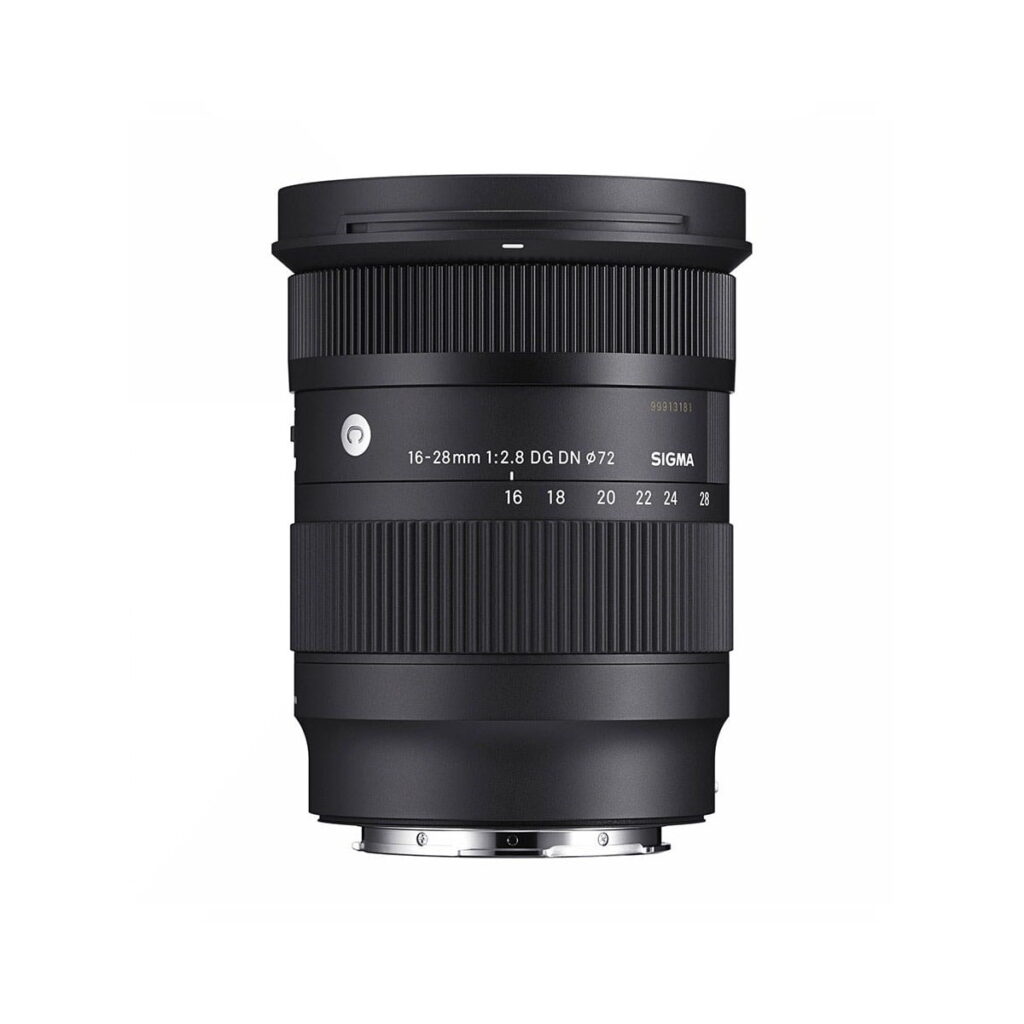 Sigma-16-28mm-f2.8-DG-DN-C-2 The Sigma 16-28mm f/2.8 DG DN DN Contemporary lens (Sony E), black, stands upright against a white background, with its focus ring and zoom ring, lens markings and label information visible.
