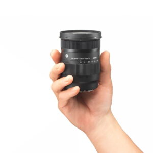 Sigma-16-28mm-f2.8-DG-DN-C-3 Hand holding the Sigma 16-28mm f/2.8 DG DN Contemporary lens for Sony E against a white background.