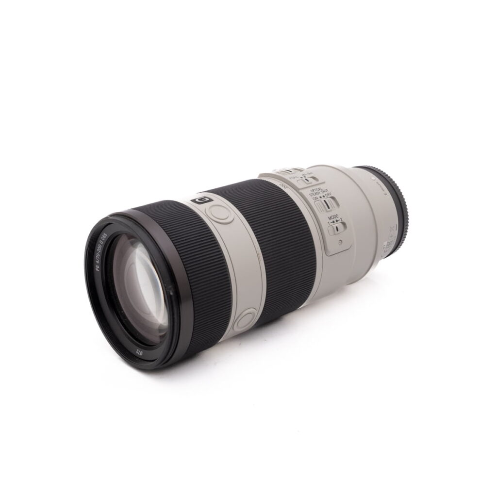 Sony FE 70-200mm f/4 OSS (Kunto K4.5) - Käytetty, teleobjektiivi, jossa on musta kahva, useita säätökytkimiä ja vaaleanharmaa tynnyri, näkyy valkoisella pohjalla.