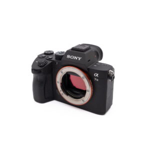 Sony-A7III-274-2 Sony A7 III (SC 2800, Kunto K5) - Käytetty peilitön kamerarunko on kuvattu oikealle, ilman objektiivia ja kenno näkyvissä valkoista taustaa vasten.