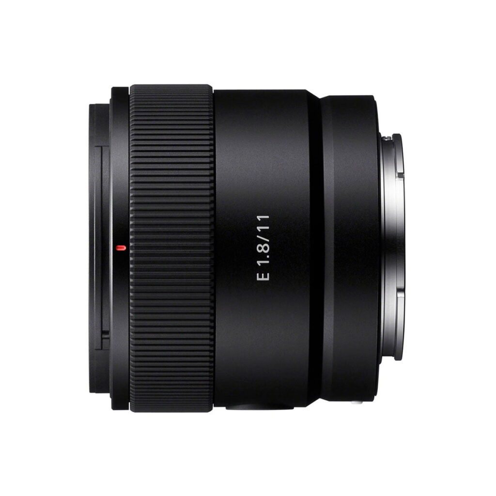 Sony-E-11mm-f1.8-4 Sony E 11mm f/1.8 -objektiivi näkyy valkoista taustaa vasten, ja siinä on musta viimeistely, E 1.8/11 -merkintä sivussa, kuvioitu tarkennusrengas ja hopeinen kiinnike oikealla.