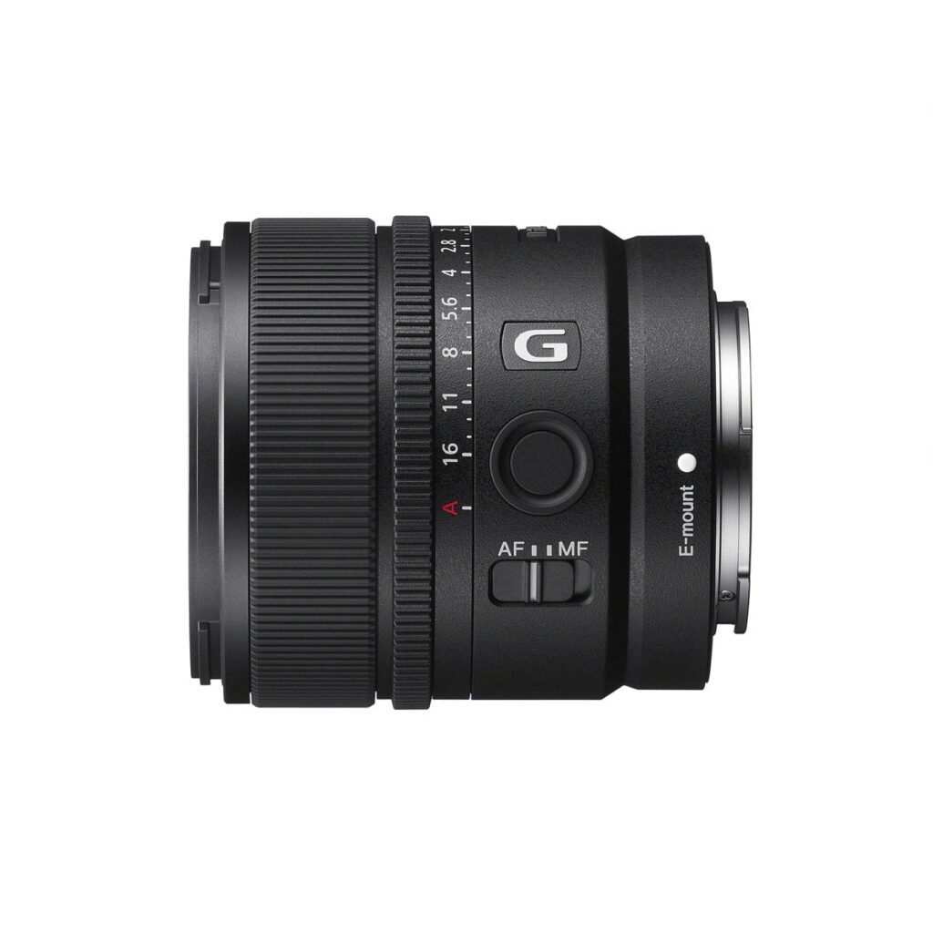 Sony E 15mm f/1.4 G -objektiivi, musta kameraobjektiivi, jonka sivulla on säätörenkaat, A- ja G-merkinnät sekä AF/MF-kytkimet, näkyy valkoisella pohjalla.