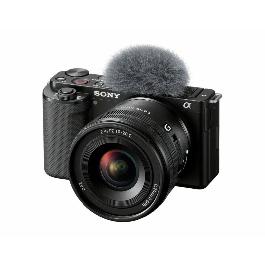 Sony-E-PZ-10-20mm-f4-G-1 Sony E PZ 10-20mm f/4 G -objektiivi, joka on kiinnitetty mustaan digitaalikameraan, jonka päällä on pörröinen harmaa mikrofonisuojus, valkoista taustaa vasten.