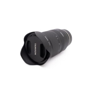 Black Tamron 28-75mm f/2.8 Di III RXD Sony E (used) lens with lens cover, with white background.