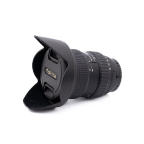 Nikon AF-S Nikkor 50mm f/1.8 G (Kunto K4.5) -objektiivi, johon on kiinnitetty vastavalosuoja, makaa kyljellään valkoista taustaa vasten. Objektiivin suojuksessa on Nikonin logo. Kyseessä on käytetty tuote (Käytetty).