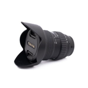 Nikon AF-S Nikkor 50mm f/1.8 G (Kunto K4.5) -objektiivi, johon on kiinnitetty vastavalosuoja, makaa kyljellään valkoista taustaa vasten. Objektiivin suojuksessa on Nikonin logo. Kyseessä on käytetty tuote (Käytetty).