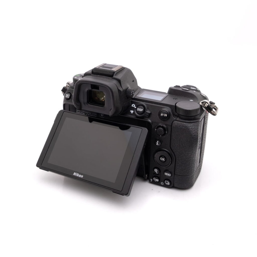 Nikon Z7 II (SC 8500, Takuu 12kk) - Käytetty digikamera mustana, takaosan nestekidenäyttö käännettynä ulospäin ohjauspainikkeiden ja valintakiekkojen näyttämiseksi, kuvattu valkoisella pohjalla.