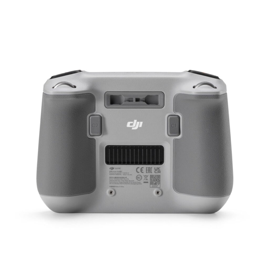 DJI RC Smart Controller -ohjaimen -ohjain, jossa on kaksi ohjauspainiketta, kuvioidut kahvat ja säädösluonteiset tuoteselosteet alareunassa, takanäkymä.