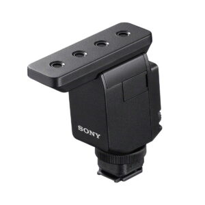 Sony-ECM-B10 Sony ECM-B10 Mikrofoni on musta suorakaiteen muotoinen lisävaruste, jossa on neljä pyöreää reikää yläosassa ja kiinnitysalusta, kuvassa eristettynä valkoisella pohjalla.