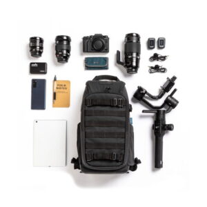 Tenba-axis V2-16L-10 A photo of a photo kit including a Tenba Axis V2 16L Backpack, three camera lenses, camera, two memory cards, cables, smartphone, notepad, pen, hard drive, tablet and camera gimbal.