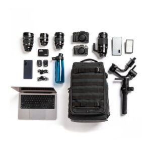 Tenba-axis-V2-20L-8 Tasainen asetelma valokuvausvälineet, kuten Tenba Axis V2 20L Backpack -kamerareppu, kameran objektiivit, kaksi kameraa, kannettava tietokone, älypuhelin, vesipullo, gimbal, muistikortit, akut, laturit ja kaapelit siististi valkoisella pohjalla.