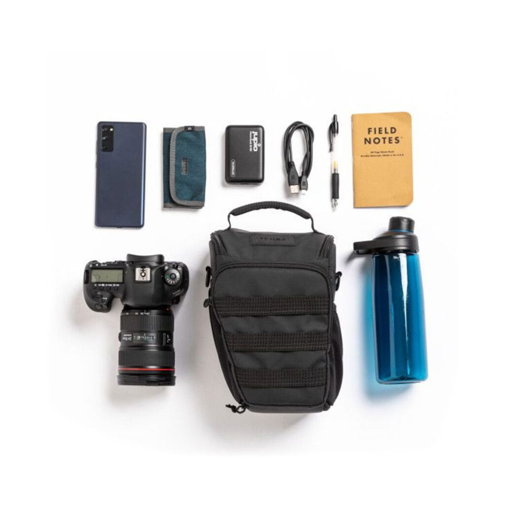 Tenba-axis V2-4L-6 Flat everyday carry case: smartphone, wallet, external hard drive, cables, pen, small notebook, camera and lens, Tenba Axis V2 4L Top Loader bag and blue water bottle with white base.