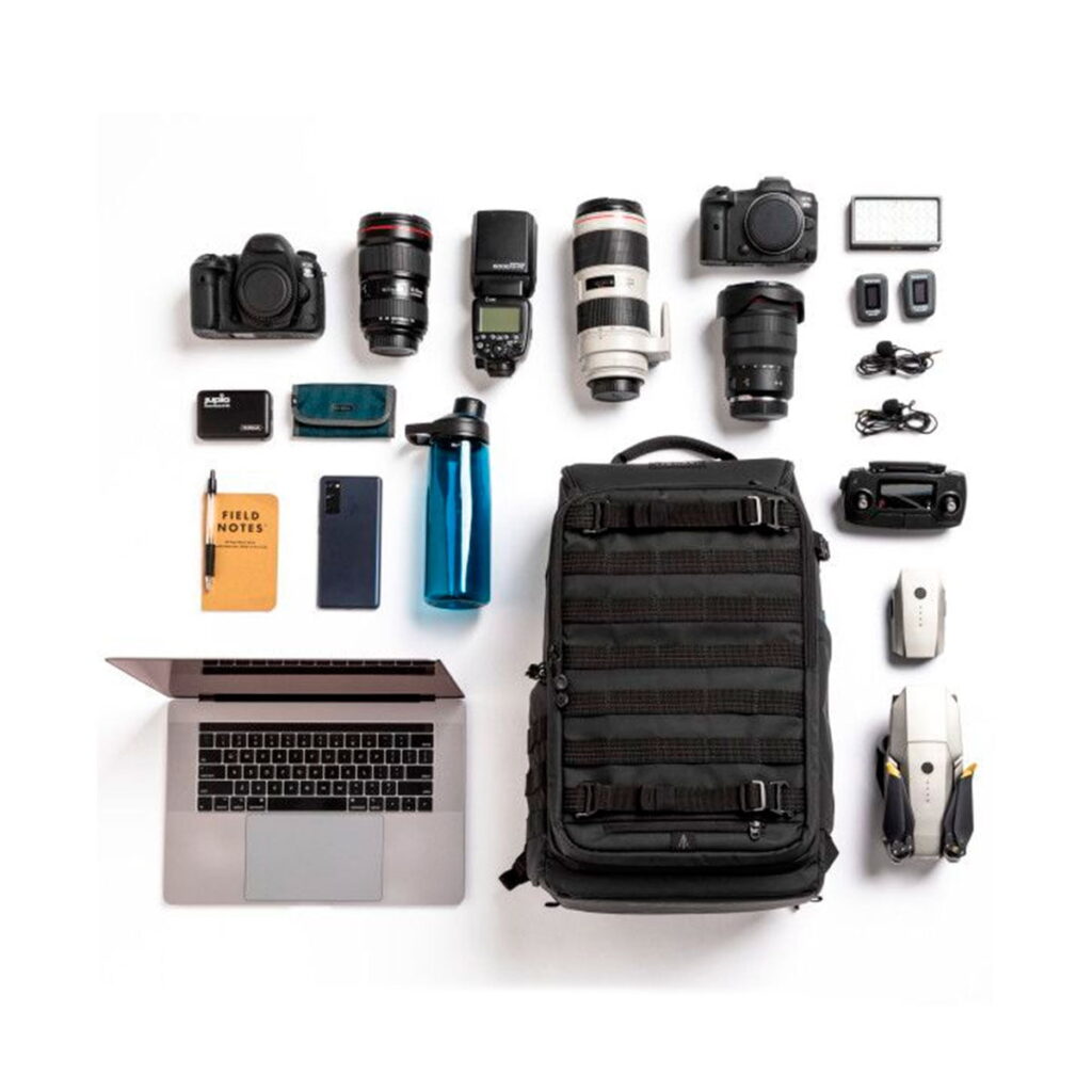 Tenta-axis V2-8 Flat lay photo of the Tenba Axis V2 24L backpack with two cameras, lenses, laptop, notebook, phone, water bottle, drone, mouse, chargers and accessories neatly arranged on a white background.