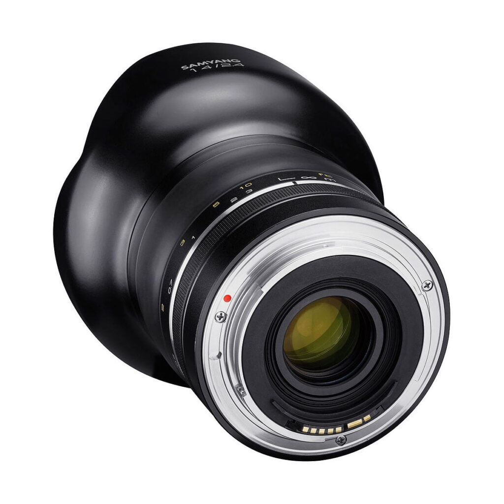 Samyang_14mm_f_2_4_XP_004 Lähikuva Samyang XP 14mm f/2.4 - Canon EF -objektiivista takakiinnityspuolelta, jossa korostuvat metalliset koskettimet, lasielementit ja mustassa tynnyrissä olevat tarkennus- ja aukkomerkinnät.