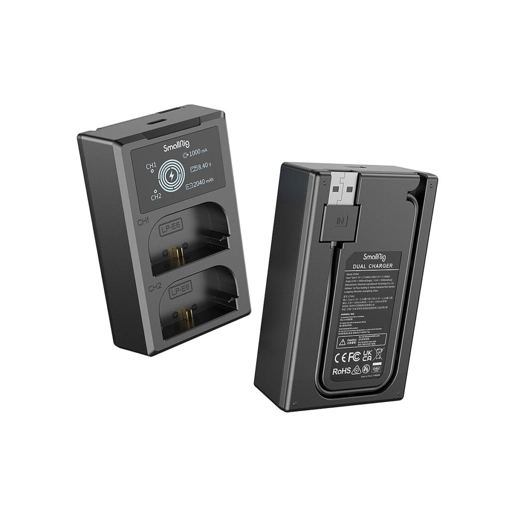 SmallRig_LP-E6NH_Camera_Battery_and_Charger_Kit_3821_003 Kaksi mustaa SmallRig 3821 LP-E6NH -kameran akku- ja laturisarjaa on esillä: toisessa on etupuoli, jossa on kaksi latauspaikkaa ja LED-näyttö, toisessa takapuoli, jossa on tuotetiedot ja USB-tuloliitäntä.